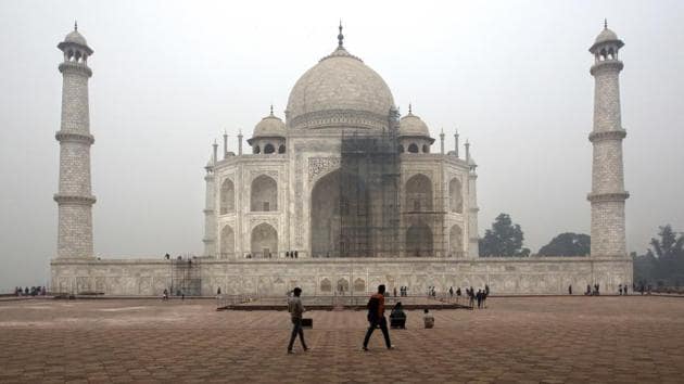 Tourists walk around Taj Mahal as workers clean the monument in Agra.(AP File Photo)