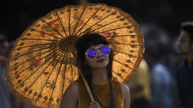 The weekend racing carnival saw evening races on February 3, while Sunday’s races started at 2.30pm. The Derby has always called for formal dressing. Here, a young woman flaunts a Japanese-style umbrella to beat the heat. (Pratik Chorge / HT Photo)