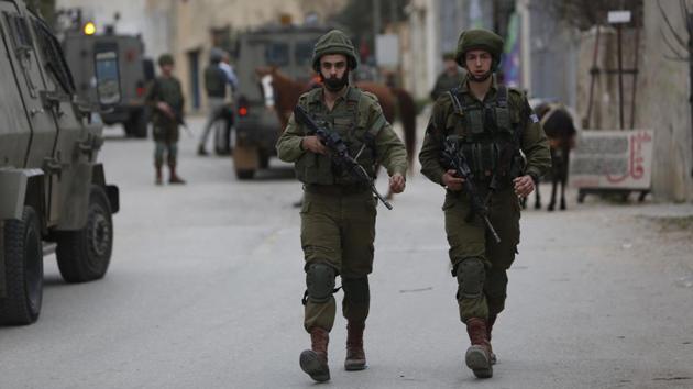 Israeli soldiers search for a Palestinian attacker in Kifl Haris village near the Ariel settlement on February 5, 2018. A Palestinian stabbed an Israeli man to death at a bus stop near Ariel on Monday before fleeing the scene, police said.(AP)