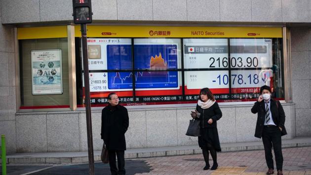 Pedestrians stand next to an electronics stock indicator showing share prices at the Tokyo Stock Exchange in Tokyo on February 6, 2018. (AFP) Pedestrians stand next to an electronics stock indicator showing share prices at the Tokyo Stock Exchange in Tokyo on February 6, 2018. (AFP)
