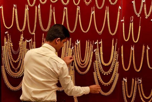 A salesman arranges gold jewellery on a display board inside a showroom during Akshaya Tritiya, a major gold buying festival, in Kochi.(Reuters FILE)