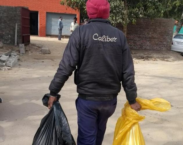 A sanitary worker carrying biomedical waste with bare hands at Government Multi-Specialty Hospital, Sector 16.(HT PHOTO)