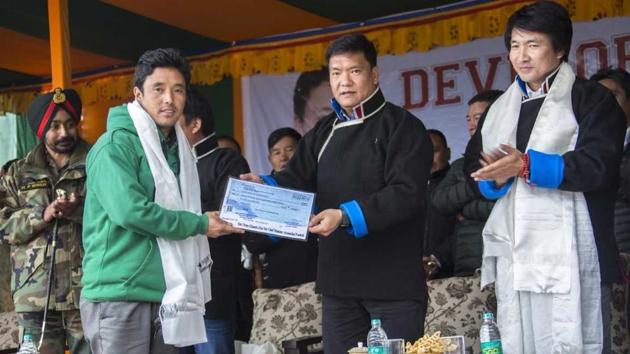 Arunchal Pradesh chief minister Pema Khandu hands over a compensation cheque to a Bomja resident at a function on Wednesday. (HT) Arunchal Pradesh chief minister Pema Khandu hands over a compensation cheque to a Bomja resident at a function on Wednesday. (HT)