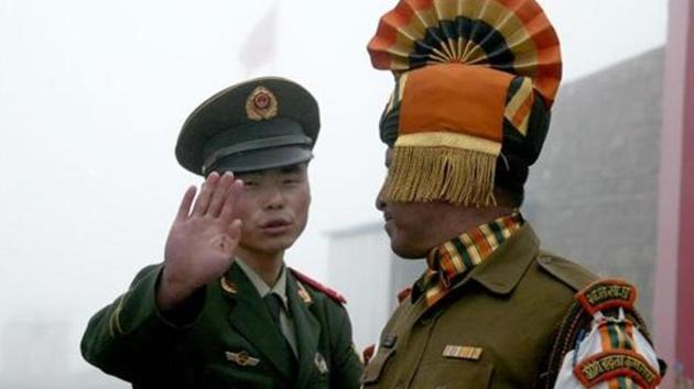 A Chinese soldier gestures next to an Indian soldier at the Nathu La border crossing between India and China in Sikkim. (AFP File Photo) A Chinese soldier gestures next to an Indian soldier at the Nathu La border crossing between India and China in Sikkim. (AFP File Photo)