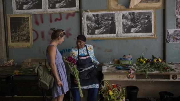 Faldela Dixon (R) talks to a customer at her flower shop in Cape Town. Dixon says customers don't buy as many flowers because of the drought, as they don't want to waste water on the flowers. From Cape Town’s elegant suburbs to its gritty townships, people are working to reduce their water consumption across the board. (Bram Janssen / AP) Faldela Dixon (R) talks to a customer at her flower shop in Cape Town. Dixon says customers don't buy as many flowers because of the drought, as they don't want to waste water on the flowers. From Cape Town’s elegant suburbs to its gritty townships, people are working to reduce their water consumption across the board. (Bram Janssen / AP)