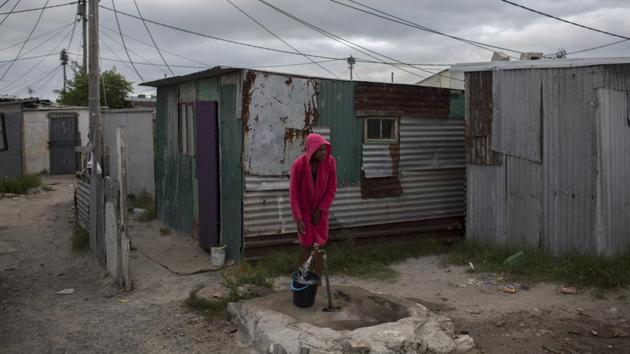 A woman collects water in a settlement near Cape Town. Some say poorer residents are unfairly blamed as concerns rise over wasting water. About a quarter of Cape Town's population lives in the informal settlements, where they get water from communal taps instead of individual taps at home like in the richer suburbs. (Bram Janssen / AP) A woman collects water in a settlement near Cape Town. Some say poorer residents are unfairly blamed as concerns rise over wasting water. About a quarter of Cape Town's population lives in the informal settlements, where they get water from communal taps instead of individual taps at home like in the richer suburbs. (Bram Janssen / AP)