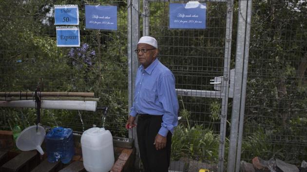 A man taps water from a source of natural spring water with a message hanging behind him that reads “Help each other... 25l for you, 25l for me” in Cape Town. People have been restricting how often and how long they shower, wash clothes and flush toilets in order to conserve water. (Bram Janssen / AP) A man taps water from a source of natural spring water with a message hanging behind him that reads “Help each other... 25l for you, 25l for me” in Cape Town. People have been restricting how often and how long they shower, wash clothes and flush toilets in order to conserve water. (Bram Janssen / AP)