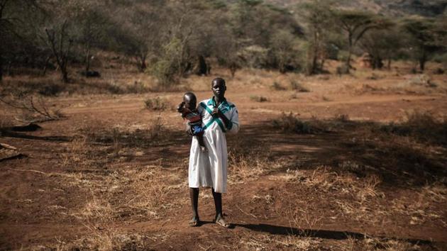 16-year-old Chematu Cheraiman, who has not undergone FGM, holds her one and half year old son in Katabok village. The main challenges in implementing the ban in these areas of Uganda and Kenya include the low capacity of law enforcement officers, harsh terrain that makes patrolling difficult and limited resources. (Yasuyoshi Chiba / AFP) 