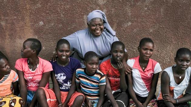 Magdalene Nantongo (C), head teacher at the government-sponsored Kalas Primary School, poses with students in Amudat town. Kalas is one of three schools in Karamoja designated a haven for girls fleeing child marriage and genital mutilation. She works with the police to ensure girls who come to her are protected. (Yasuyoshi Chiba / AFP) 