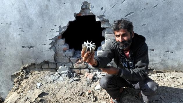 A villager shows a mortar shell near damaged wall of his house fired by Pakistan of the border at Arnia sector in Jammu on January 19. In just this year, at least 19 soldiers have been killed on both sides during ceasefire violations.(Nitin Kantora/HT File Photo)