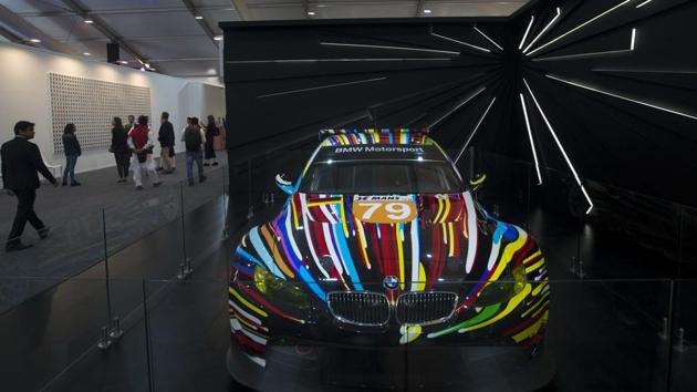 Visitors walk past an art on a BMW car by Jeff Koons during the India Art Fair in New Delhi on February 9, 2018.(AP/Manish Swarup)