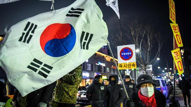 A woman holds the South Korean flag outside the stadium during the opening ceremony. (AFP) A woman holds the South Korean flag outside the stadium during the opening ceremony. (AFP)