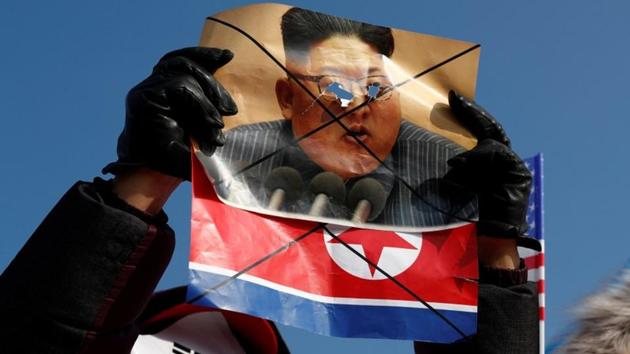 A demonstrator holds a defaced portrait of North Korean leader Kim Jong Un during an anti-North Korea protest before the opening ceremony for the Pyeongchang 2018 Winter Olympics in Pyeongchang. (REUTERS)