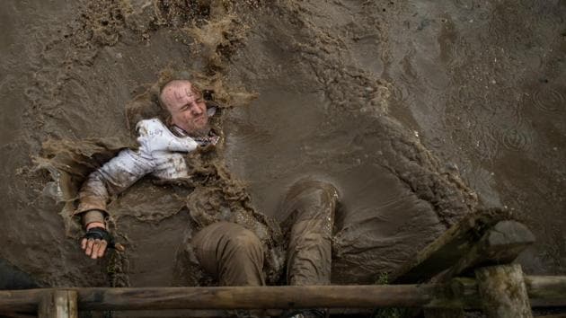 A competitor dressed in a white suit falls into muddy water as he negotiates an obstacle in the Tough Guy endurance event near Wolverhampton, England on February 4, 2018. (Oli Scarff / AFP) A competitor dressed in a white suit falls into muddy water as he negotiates an obstacle in the Tough Guy endurance event near Wolverhampton, England on February 4, 2018. (Oli Scarff / AFP)