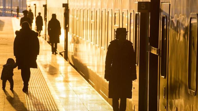 Staff members (R) secure the doors of a train at Hankou Railway Station in Wuhan in China's central Hubei province on February 5, 2018. China's official peak travel period for this year's Lunar New Year began on February 1 and authorities expect more than 390 million train trips between February 1 and March 12. (AFP) Staff members (R) secure the doors of a train at Hankou Railway Station in Wuhan in China's central Hubei province on February 5, 2018. China's official peak travel period for this year's Lunar New Year began on February 1 and authorities expect more than 390 million train trips between February 1 and March 12. (AFP)