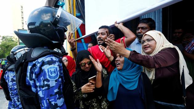 Maldivian opposition supporters argue with a police officer near the main opposition Maldives Democratic Party headquarters during a protest demanding the government to release jailed opposition leaders. (REUTERS)