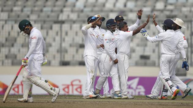 Sri Lanka's Rangana Herath, center, celebrate with his teammates the dismissal of Bangladesh's Mushfiqur Rahim, left, during the third day of the second and final Test in Dhaka, Bangladesh on Saturday.(AP)