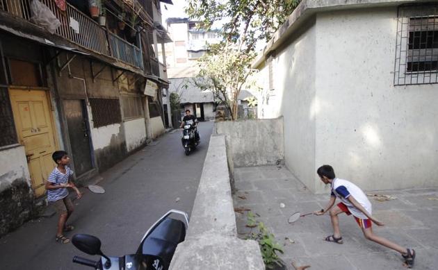 MUMBAI: Kids play badminton across a narrow street as a vehicle heads towards them. (Hemanshi Kamani / HT Photo)
