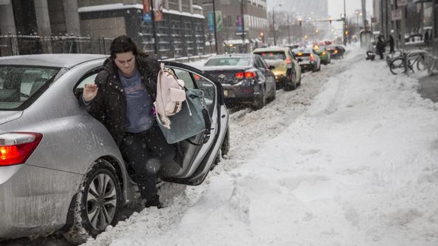 A woman exits a car during a snowstorm in Chicago. The upper Midwest is preparing for a wintry blast as a winter storm is expected across the region, with forecasters saying up to a foot of snow is expected in some areas. (AP Photo) A woman exits a car during a snowstorm in Chicago. The upper Midwest is preparing for a wintry blast as a winter storm is expected across the region, with forecasters saying up to a foot of snow is expected in some areas. (AP Photo)