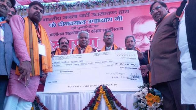 BJP leaders present a cheque to Ramlal in Dehradun on Sunday.(HT PHOTO)