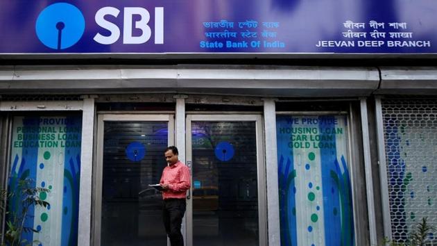 A man checks his mobile phones in front of State Bank of India (SBI) branch in Kolkata, February 9, 2018. (REUTERS) A man checks his mobile phones in front of State Bank of India (SBI) branch in Kolkata, February 9, 2018. (REUTERS)