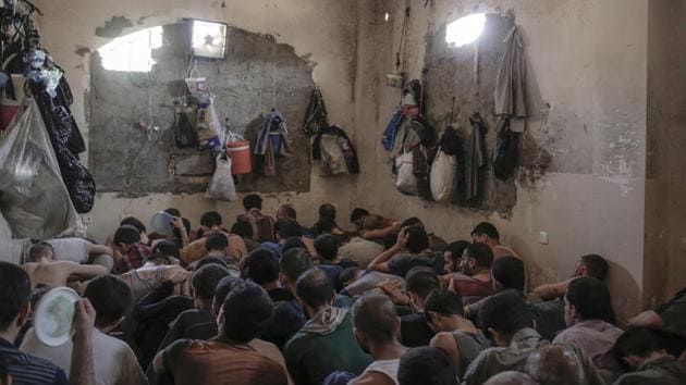 Suspected Islamic State members sit inside a small room in a prison south of Mosul.(AP File Photo)