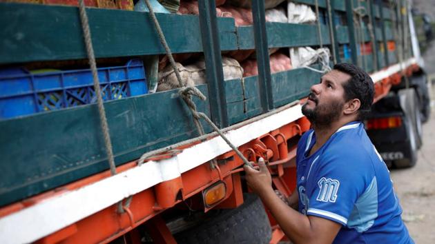 Aguilar fastens his cargo with rope on a truck. Just a few days earlier, Aguilar said he sat terrified when hundreds of looters swarmed a stationary convoy, overwhelming drivers by sheer numbers. They carted off milk, rice and sugar from other trucks but left his less-prized vegetables alone. “Every time I say goodbye to my family, I entrust myself to God and the Virgin,” said the 36-year-old trucker. (Carlos Garcia Rawlins / REUTERS) Aguilar fastens his cargo with rope on a truck. Just a few days earlier, Aguilar said he sat terrified when hundreds of looters swarmed a stationary convoy, overwhelming drivers by sheer numbers. They carted off milk, rice and sugar from other trucks but left his less-prized vegetables alone. “Every time I say goodbye to my family, I entrust myself to God and the Virgin,” said the 36-year-old trucker. (Carlos Garcia Rawlins / REUTERS)