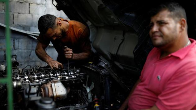 Mechanics repair a truck that hasn’t been operational due to a shortage of spares. The looters are particularly fond of “miguelitos” - pieces of metal with long spikes - to burst tires and halt vehicles. With new tires now going for about 70 million bolivars - about $300 on the black market or more than two decades of work at the official minimum wage - looters often swipe them along with food. (Carlos Garcia Rawlins / REUTERS) Mechanics repair a truck that hasn’t been operational due to a shortage of spares. The looters are particularly fond of “miguelitos” - pieces of metal with long spikes - to burst tires and halt vehicles. With new tires now going for about 70 million bolivars - about $300 on the black market or more than two decades of work at the official minimum wage - looters often swipe them along with food. (Carlos Garcia Rawlins / REUTERS)