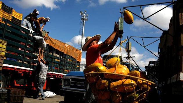 Workers load merchandise into Aguilar’s truck next to a papaya seller in Barquisimeto, Venezuela. While truck heists have long been common from Mexico to Brazil, looting of cargoes on roads has soared in Venezuela in recent times and appears directly linked to growing hunger and desperation. (Carlos Garcia Rawlins / REUTERS) Workers load merchandise into Aguilar’s truck next to a papaya seller in Barquisimeto, Venezuela. While truck heists have long been common from Mexico to Brazil, looting of cargoes on roads has soared in Venezuela in recent times and appears directly linked to growing hunger and desperation. (Carlos Garcia Rawlins / REUTERS)