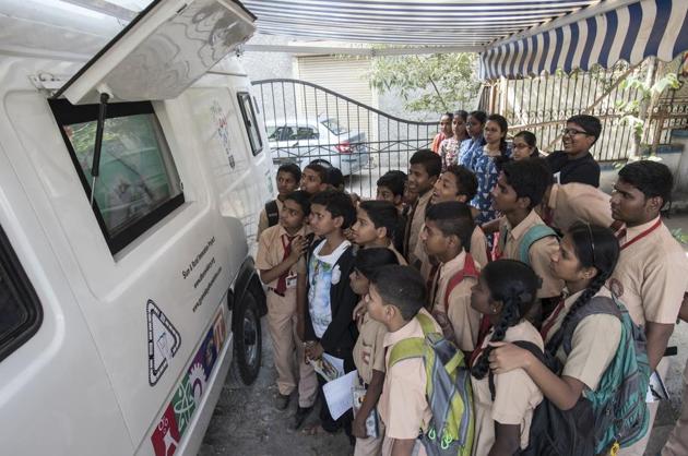 Students learn from watching videos on the solar-powered screen of the mobile van in Dharavi on Friday. (HT PHOTO) Students learn from watching videos on the solar-powered screen of the mobile van in Dharavi on Friday. (HT PHOTO)