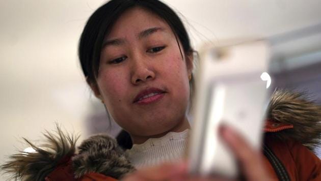 Jia Weiwei demonstrates how to play the Japanese mobile game Travel Frog on her smartphone in Beijing.(AP)