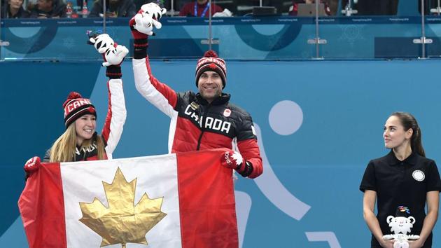 Third-placed Russia's Anastasia Bryzgalova (R) watches as winners Canada's Kaitlyn Lawes and John Morris celebrate on the podium during the curling mixed doubles venue ceremony at the Pyeongchang 2018 Winter Olympic Games at the Gangneung Curling Centre in Gangneung on February 13, 2018. (AFP) Third-placed Russia's Anastasia Bryzgalova (R) watches as winners Canada's Kaitlyn Lawes and John Morris celebrate on the podium during the curling mixed doubles venue ceremony at the Pyeongchang 2018 Winter Olympic Games at the Gangneung Curling Centre in Gangneung on February 13, 2018. (AFP)