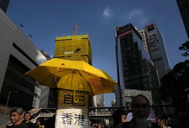 A protester holds a yellow umbrella during a march at a downtown street in Hong Kong on December 3, 2017. (AP) A protester holds a yellow umbrella during a march at a downtown street in Hong Kong on December 3, 2017. (AP)