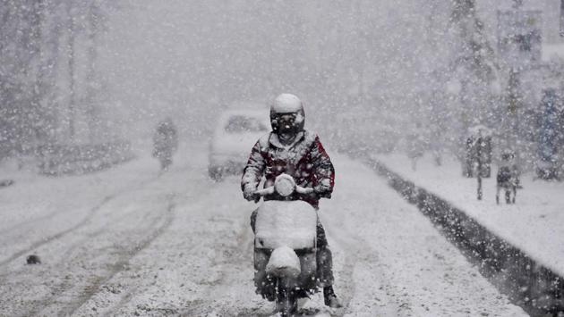 A man rides a scooter as it snows in Srinagar. The snowfall in Kashmir snapped links with the rest of the country as the arterial Jammu-Srinagar National Highway was closed due to accumulation of snow around Jawahar Tunnel in the Qazigund area. The snowfall also led to poor visibility at the Srinagar airport, disrupting the air traffic. (Waseem Andrabi / HT Photo) A man rides a scooter as it snows in Srinagar. The snowfall in Kashmir snapped links with the rest of the country as the arterial Jammu-Srinagar National Highway was closed due to accumulation of snow around Jawahar Tunnel in the Qazigund area. The snowfall also led to poor visibility at the Srinagar airport, disrupting the air traffic. (Waseem Andrabi / HT Photo)