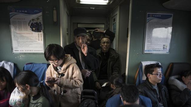Passengers aboard a crowded train leave from the station in Beijing. Travellers must be home by Thursday to usher in the New Year on Friday. But getting there is an ordeal. Only the lucky passengers were able to snag a seat. Many had to stand for the entire trip, clogging the aisles and meals on plastic trays were passed from passenger to passenger. (Fred Dufour / AFP) Passengers aboard a crowded train leave from the station in Beijing. Travellers must be home by Thursday to usher in the New Year on Friday. But getting there is an ordeal. Only the lucky passengers were able to snag a seat. Many had to stand for the entire trip, clogging the aisles and meals on plastic trays were passed from passenger to passenger. (Fred Dufour / AFP)