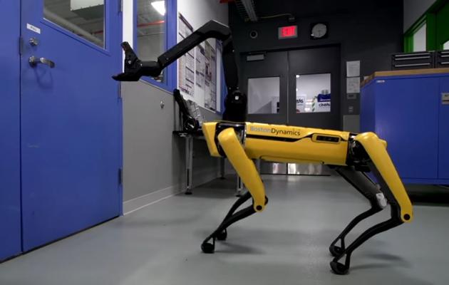 The SpotMini with an arm extending out of its head.