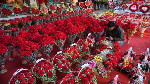 A shopkeeper places rose bouquets to attract customers on the eve of Valentine’s Day in Sector 35 on Tuesday.(Karun Sharma/HT)