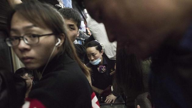 A waitress (C) tries to make her way through passengers on a crowded car. Passengers made 732 million trips from February 1 to February 10 for this year’s holiday travel period, down by 3% from last year. The transport ministry attributed the drop to university students and migrant workers who returned home during the November and December evictions. (Fred Dufour / AFP) A waitress (C) tries to make her way through passengers on a crowded car. Passengers made 732 million trips from February 1 to February 10 for this year’s holiday travel period, down by 3% from last year. The transport ministry attributed the drop to university students and migrant workers who returned home during the November and December evictions. (Fred Dufour / AFP)