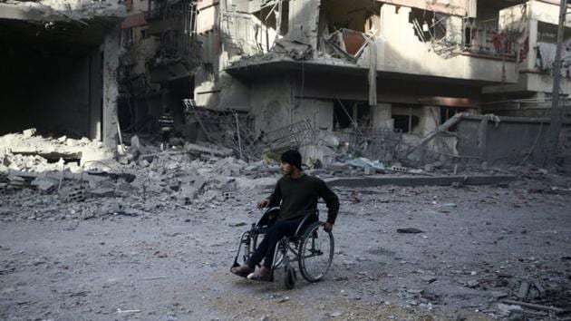 A man in a wheelchair at a damaged site after an airstrike in the besieged town of Douma, Eastern Ghouta, Damascus, Syria on February 9, 2018. According to Washington, at least six chlorine attacks have been reported since early January in rebel-held areas, resulting in dozens of injuries.(Reuters File Photo)