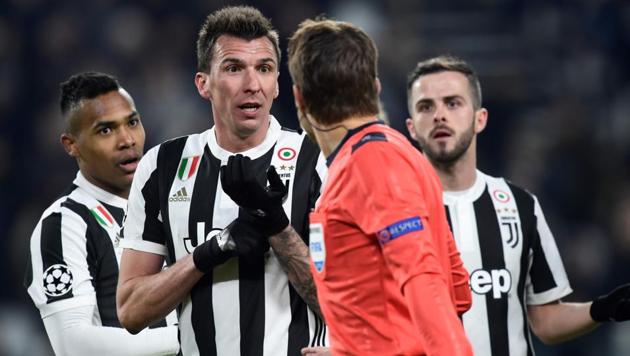 Juventus' forward from Croatia Mario Mandzukic (2L) speaks with referee Felix Brych during the UEFA Champions League Round of 16 first leg football match against Tottenham Hotspur at the Allianz Stadium in Turin on Tuesday.(AFP)