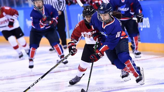 Japan's Moeko Fujimoto (L) and Unified Korea's Choi Jiyeon chase the puck in the women's preliminary round ice hockey match during the Pyeongchang 2018 Winter Olympic Games at the Kwandong Hockey Centre in Gangneung on Wednesday. (AFP) Japan's Moeko Fujimoto (L) and Unified Korea's Choi Jiyeon chase the puck in the women's preliminary round ice hockey match during the Pyeongchang 2018 Winter Olympic Games at the Kwandong Hockey Centre in Gangneung on Wednesday. (AFP)
