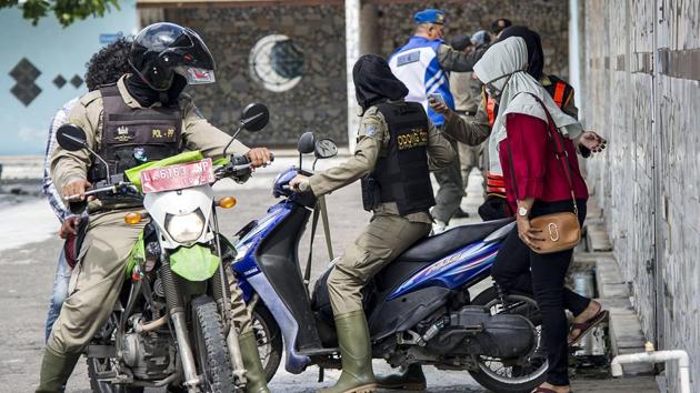 Indonesian officers from the city administration police detain unmarried couples after a raid at a hotel in Surabaya on Wednesday. (AFP) Indonesian officers from the city administration police detain unmarried couples after a raid at a hotel in Surabaya on Wednesday. (AFP)