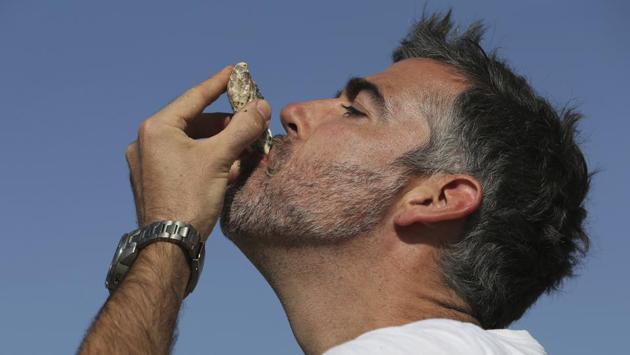 Ramie Murray tests a fresh oyster the only way there is. The Pacific Cupped oysters, he said, “grow very well in the summer and their growth tails off in the winter, whereas here they just grow continuously because we have the warm weather the whole year round.” (Kamran Jebreili / AP) Ramie Murray tests a fresh oyster the only way there is. The Pacific Cupped oysters, he said, “grow very well in the summer and their growth tails off in the winter, whereas here they just grow continuously because we have the warm weather the whole year round.” (Kamran Jebreili / AP)
