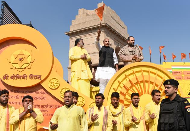 Waving a saffron flag, Home Minister Rajnath Singh kicked off the rath yatra from the India Gate lawns that would collect soil and water for a week-long Vedic yagya in March. The Rashtriya Raksha Mahayagya is slated to be held from March 18-25 on the lawns outside the Red Fort, involving over 1,100 priests. (Sushil Kumar / HT Photo) 