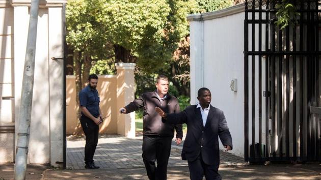 Private Security agents gesture as they stand guard outside the compound of the controversial business family Gupta in Johannesburg, on February 14, 2018. (AFP) Private Security agents gesture as they stand guard outside the compound of the controversial business family Gupta in Johannesburg, on February 14, 2018. (AFP)