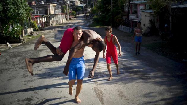 Wrestlers train in the street during championship week. Two years ago, Heredia Marrero, 55, started bringing children to Chicharrones for training and a tournament. “We did it on the spur of the moment, in a pretty improvised way,” he said. “We didn’t have referees or all the equipment we needed, but finally everyone got behind it.” (Ramon Espinosa / AP) Wrestlers train in the street during championship week. Two years ago, Heredia Marrero, 55, started bringing children to Chicharrones for training and a tournament. “We did it on the spur of the moment, in a pretty improvised way,” he said. “We didn’t have referees or all the equipment we needed, but finally everyone got behind it.” (Ramon Espinosa / AP)
