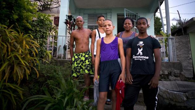 Lidia Danger (2nd R), and her husband Armando Castellano, (L), pose with three young wrestlers from Gramma province they hosted at their home during the championship. The participants stayed with 70 local families, who often depend on small donations to feed the extra mouths and entertain the kids during the seven-day tournament. (Ramon Espinosa / AP) Lidia Danger (2nd R), and her husband Armando Castellano, (L), pose with three young wrestlers from Gramma province they hosted at their home during the championship. The participants stayed with 70 local families, who often depend on small donations to feed the extra mouths and entertain the kids during the seven-day tournament. (Ramon Espinosa / AP)