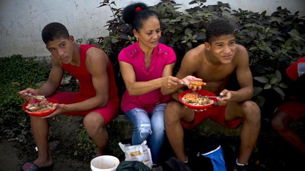 Nalis Mendoza slices a tomato as she feeds her sons, both participants in the wrestling championship. Local doctors and nurses volunteer their time to monitor the wrestlers’ health and treat any injuries, while neighbourhood children help by gathering wood to feed stoves feeding the participants in this community affair. (Ramon Espinosa / AP) Nalis Mendoza slices a tomato as she feeds her sons, both participants in the wrestling championship. Local doctors and nurses volunteer their time to monitor the wrestlers’ health and treat any injuries, while neighbourhood children help by gathering wood to feed stoves feeding the participants in this community affair. (Ramon Espinosa / AP)