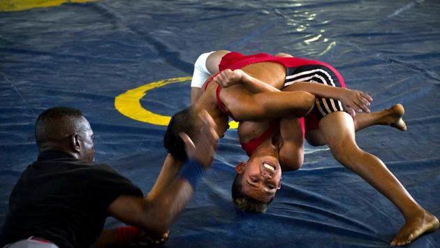 A referee, like the others trained by local sports schools for the event, prepares to pound on the mat if either wrestler's back touches the mat. The more than 150 young wrestlers were divided into teams from various provinces across Cuba and the Chicharrones neighbourhood itself. (Ramon Espinosa / AP) A referee, like the others trained by local sports schools for the event, prepares to pound on the mat if either wrestler's back touches the mat. The more than 150 young wrestlers were divided into teams from various provinces across Cuba and the Chicharrones neighbourhood itself. (Ramon Espinosa / AP)