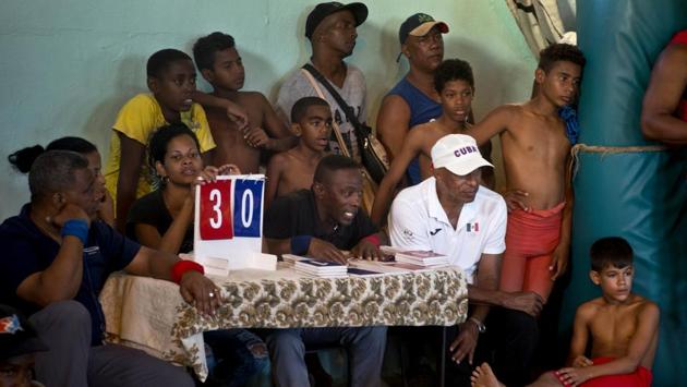 Referees, wrestlers and locals alike are glued to an ongoing match. Organiser Heredia was never a wrestler himself, but developed a fervent interest in the sport after his sons wrestled in state programs. And even though it’s not officially sanctioned, the local government gave its implicit blessing to the tournament by donating equipment. (Ramon Espinosa / AP) Referees, wrestlers and locals alike are glued to an ongoing match. Organiser Heredia was never a wrestler himself, but developed a fervent interest in the sport after his sons wrestled in state programs. And even though it’s not officially sanctioned, the local government gave its implicit blessing to the tournament by donating equipment. (Ramon Espinosa / AP)